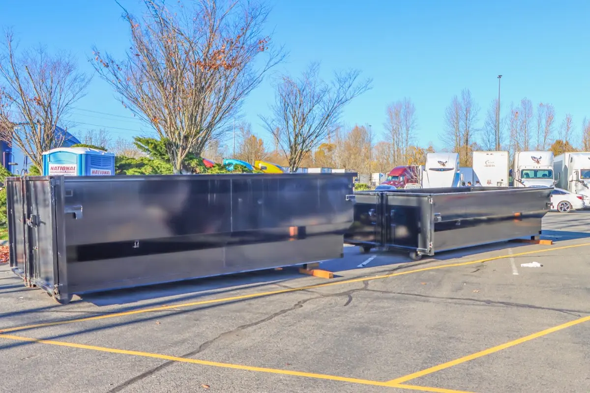 Professional dumpster rental service with roll-off container on residential driveway in Astoria